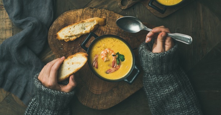 Frau isst Karottensuppe mit Gebäck | Credit: iStock.com/Foxys_forest_manufacture