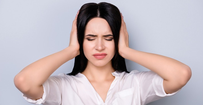 Frau hält sich Ohren zu | Credit: iStock.com/Deagreez