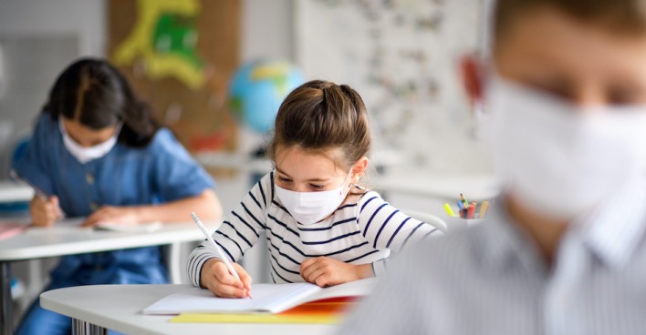 Schüler tragen Maske im Klassenzimmer | Credit: iStock.com/Halfpoint