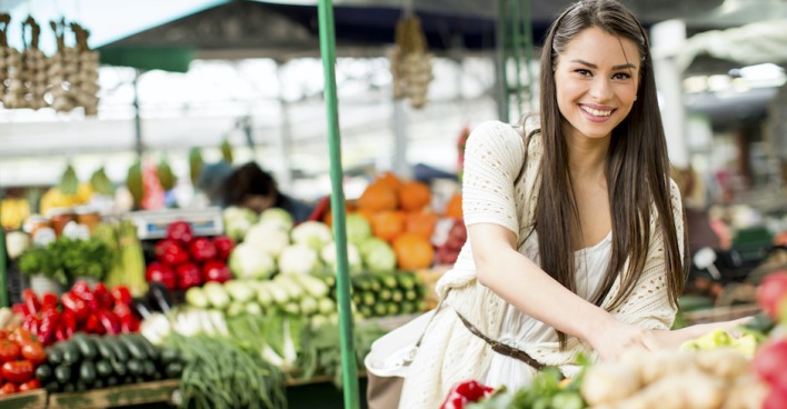 Junge Frau begutachtet das Gemüse am Markt | Credit: iStock.com/boggy22