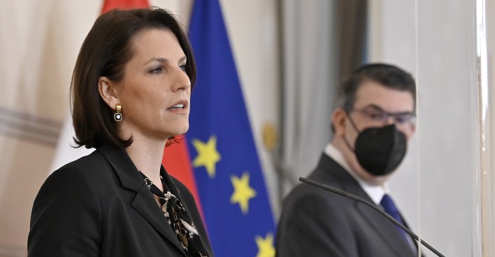 Europaministerin Karonline Edstadler bei einer Pressekonferenz vor den Flaggen Österreichs und der EU