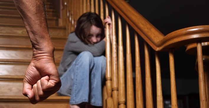 Ein Mädchen sitzt verängstigt auf der Treppe