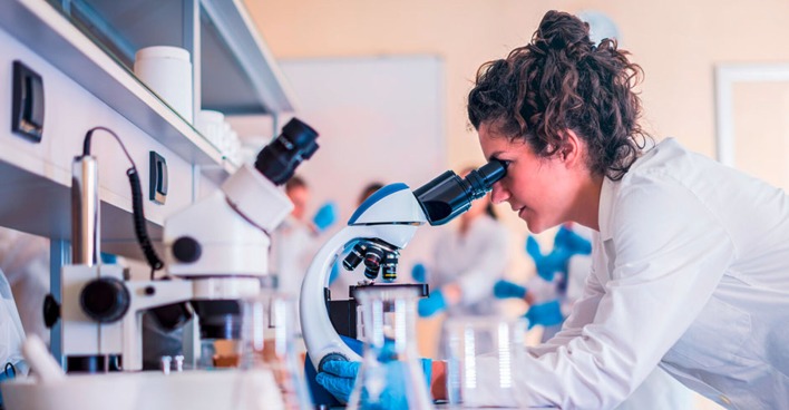 Frau nimmt am Mikroskop im Labor eine Untersuchung vor | Credit: iStock.com/Vladimir Borovic