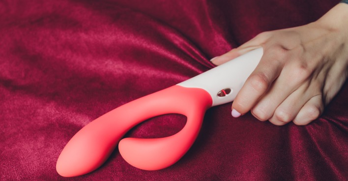 Frau hält Vibrator in der Hand