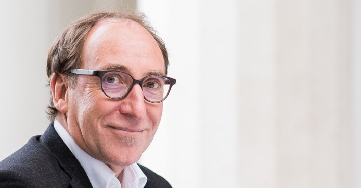 Ein Porträt-Foto von Johnannes Rauch. Er trägt eine Brille mit dunklem Rahmen und schmunzelt in die Kamera.