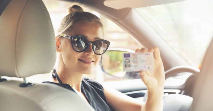 Junge Frau mit neuem Führerschein | Credit: iStock.com/ronstik