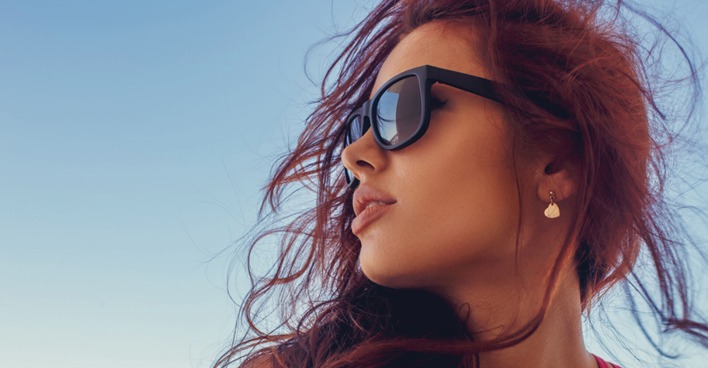 Seitenansicht einer jungen Frau mit Sonnenbrille | Credit: iStock.com/FXQuadro