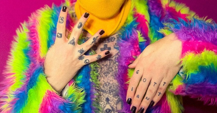 Der Influencer Ian Jules in einer regenbogenfarbenen Felljacke mit gelber Schimütze und Spiegelvisir