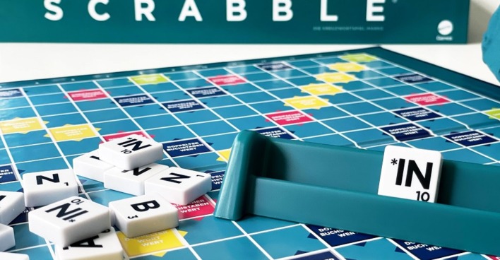 Ein Scrabbel-Spielfeld. Auf dem Buchstabenhalter ein Buchstabendstein. Darauf zu lesen Sternchen-in.