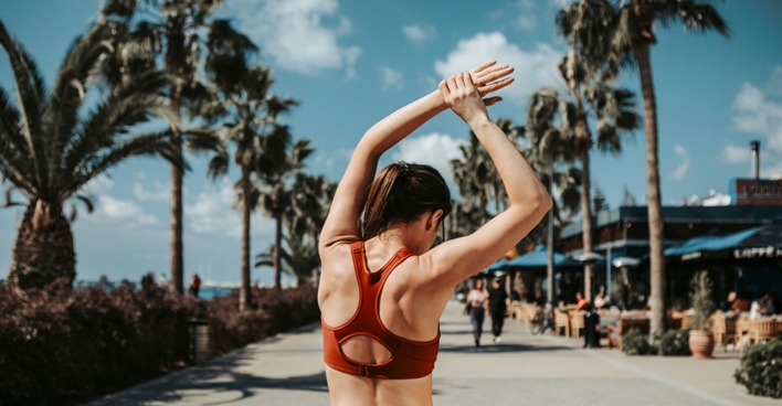 Junge Frau von hinten beim Oberarm-Training im Freien | Credit: iStock.com/YakobchukOlena