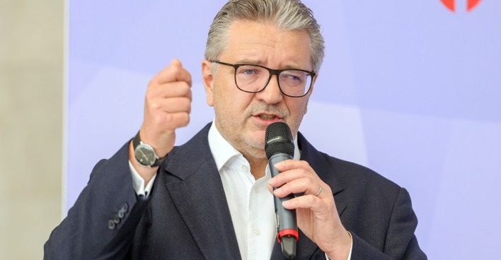 Gesundheitsstadtrat Peter Hacker mit einem Mikrofon in der Hand. Er spricht.