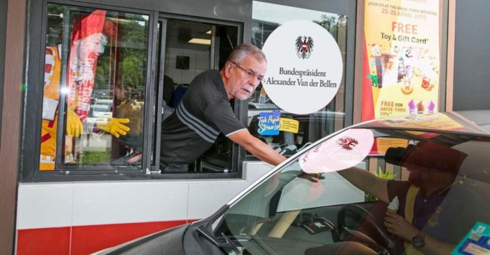 Alexander Van der Bellen reicht etwas aus einem McDonalds DriveIn-Fenster