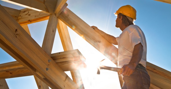 Bauarbeiter fertigt Dachstuhl aus Holz | Credit: iStock.com/sculpies