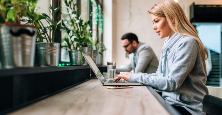 Junge Frau surft auf ihrem Notebook im Internet | Credit: iStock.com/nortonrsx