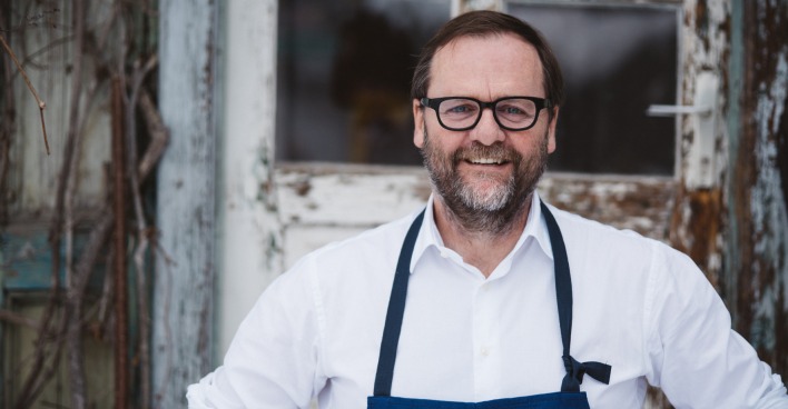 Gastronom Sepp Schellhorn mit weißem Hemd und blauer Schürze