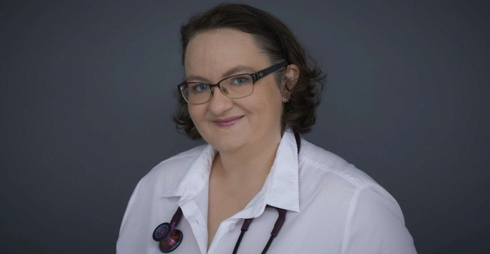 Ein Porträtfoto von Dr. Lisa-Maria Kellermayr. Sie trägt Arztkittel und Stetoskop und lächelt in die Kamera
