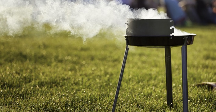 rauchender Griller auf einer Wiese | Credit: iStock.com/Canetti