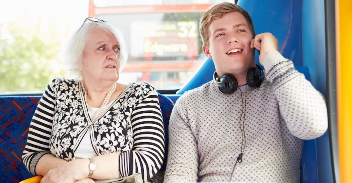 Ältere Frau und junger Mann sitzen im Bus | Credit: iStock.com/monkeybusinessimages