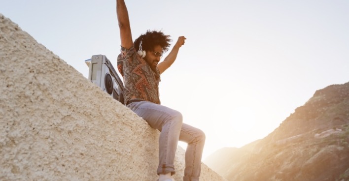 Sommer im Süden: Junger Mann hört Musik. | Credit: iStock.com/DisobeyArt