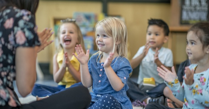 Kindergartenkinder klatschen in die Hände