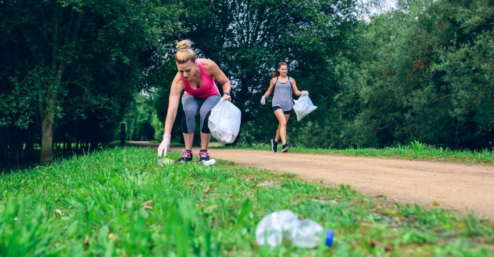 Frauen joggen und sammeln Müll ein | Credit: iStock.com/doble-d