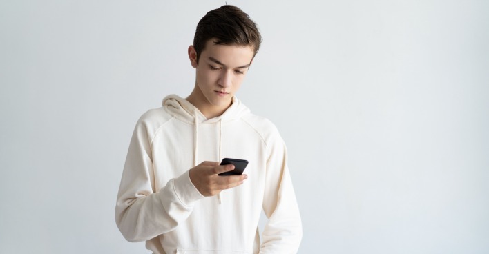 Junger Mann liest am Handy
