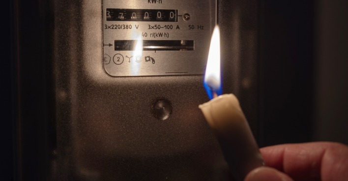 Blackout: Mit Kerze wird Stromzähler gecheckt. | Credit: iStock.com/Evgen_Prozhyrko