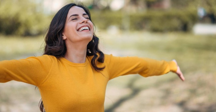 Junge Frau streckt entspannt ihre Arme weit von sich | Credit: iStock.com/nortonrsx