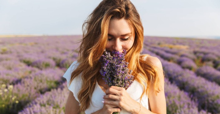 Junge Frau mit einem Bund Lavendel in der Hand | Credit: iStock.com/DeanDrobot