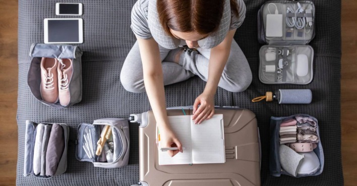 Junge Frau beim Kofferpacken | Credit: iStock.com/Kostikova