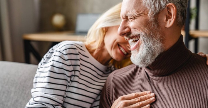 Reiferes Paar lacht gemeinsam auf der Couch | Credit: iStock.com/Inside Creative House