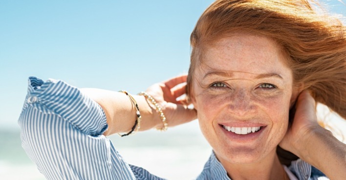 Frau lächelt und zeigt ihre geraden Zähne | Credit: iStock.com/Ridofranz
