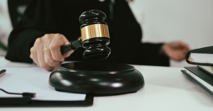 Frau hält Hammer für Gerichtsurteil in der Hand
