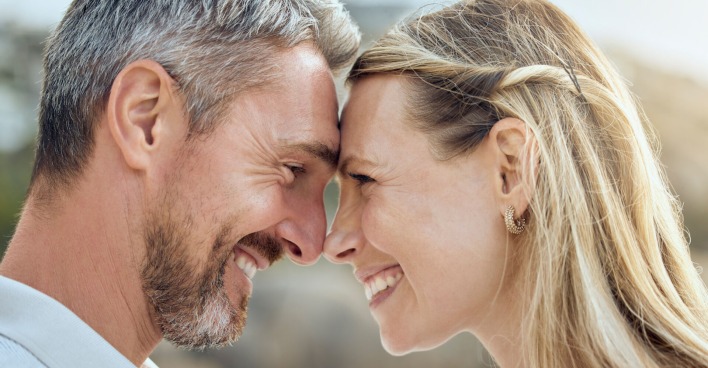 ein Mann mit grauen Haaren lächelt seine Frau an | Credit: iStock.com/PeopleImages