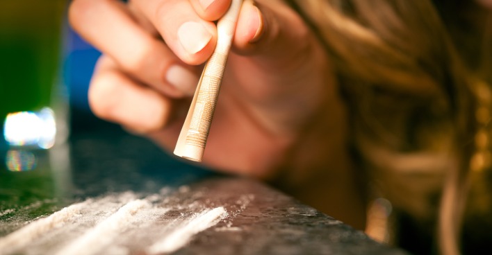Frau schnupft mit einem Geldschein Kokain | Credit: iStock.com/kzenon