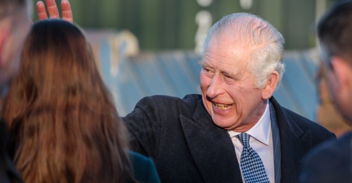 Charles III. winkt und lächelt
