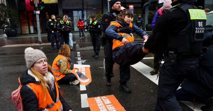 Demonstrantin wird von Polizisten weggetragen