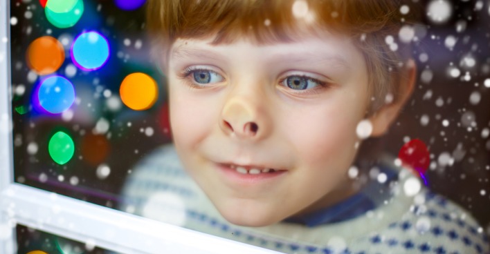 ein kleiner Junge im Pullover drückt die Nase ans Fenster | Credit: iStock.com/romrodinka