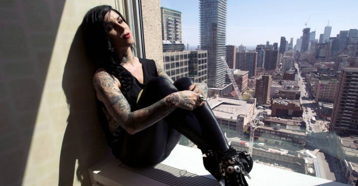 Kat von D sitzt auf der Fensterbank einer Penthouse-Wohnung mit Blick auf die umgebende Skyline | Credit: Frank Gunn / Action Press / picturedesk.com