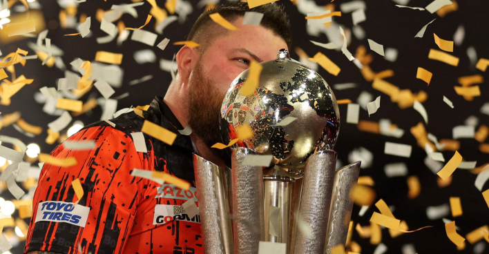 Der Darts-Spieler Michael Smith küsst, umschwirrt von einem Konfetti-Regen, die Siegestrophäe der Darts-WM