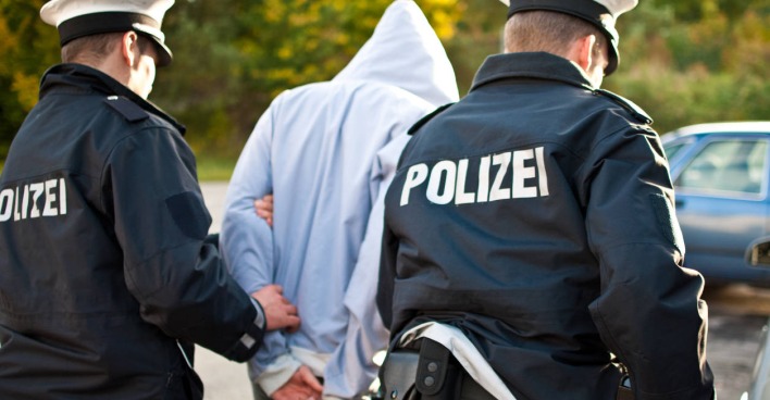 Mann wird von zwei Polizisten festgenommen