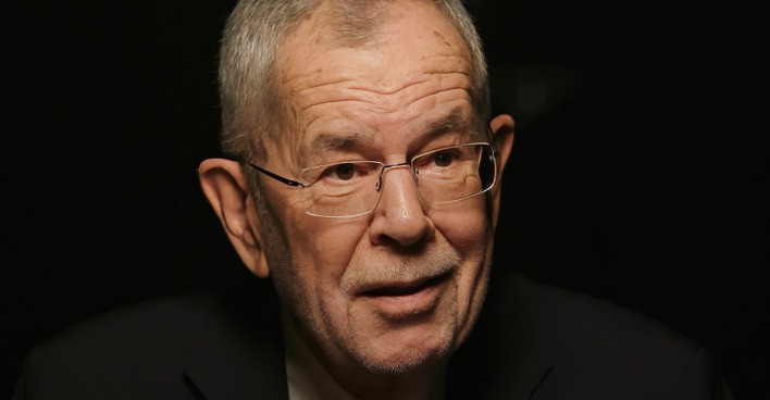Großaufnahme von Alexander Van der Bellen vor schwarzem Hintergrund.