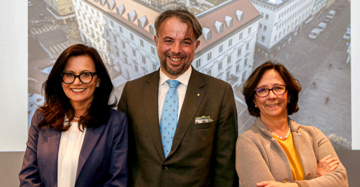 Die Vorstände der Kärntner Sparkasse vor einem auf die Rückwand projezierten Bild der Firmenzentrale
