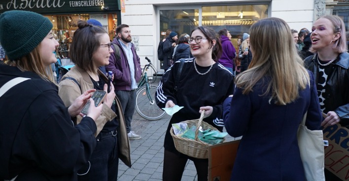 Junge Frauen bei der Verteilaktion in Graz. Sie lachen, die Stimmung wirkt gelöst.