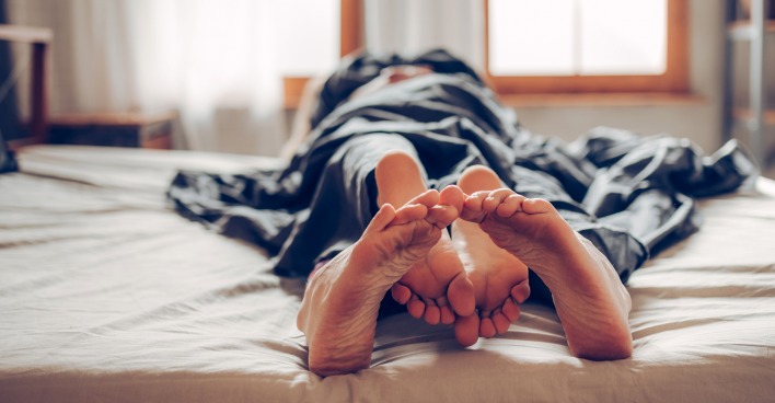 Pärchen kuschelt im Bett