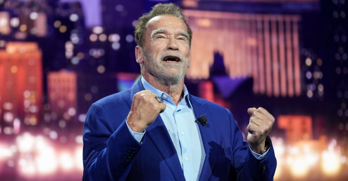 Arnold Schwarzenegger in blauem Anzug bei einer TV-Show.