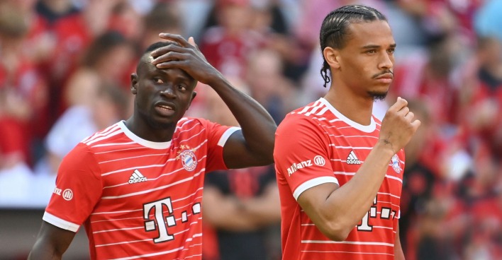 Sadio Mané und Leroy Sané, die mit ratlosem Gesichtsausdruck im Bayern-Dress über den Platz marschieren