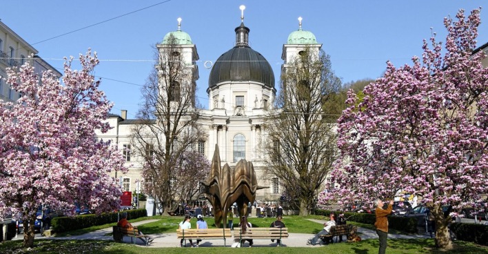 Der Makartplatz in Salzburg mit der Dreifaltigkeitskirche und blühenden Magnolien.
