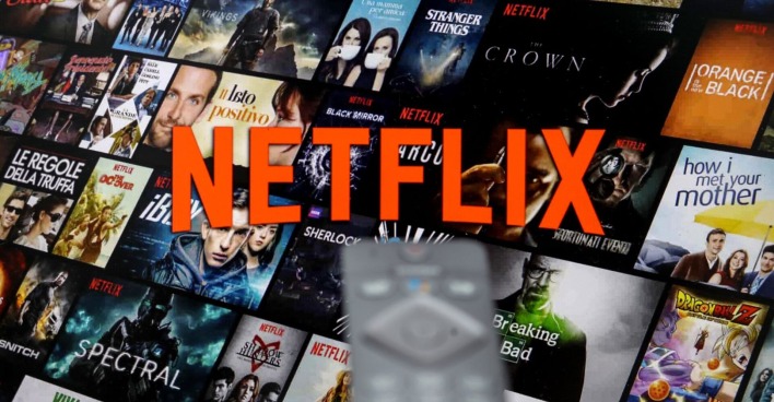 Netflix-Schriftzug mit vielen Filmen im Hintergrund.