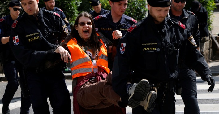 Eine Aktivistin der "Letzten Generation" wird von Polizeibeamten von der Fahrbahn getragen